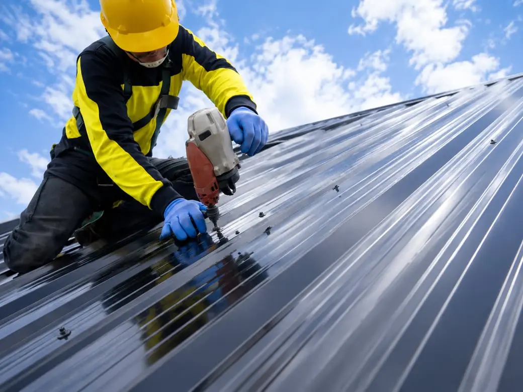 Roofer installing metal roof panels — Sunrise Contractors Sarasota FL